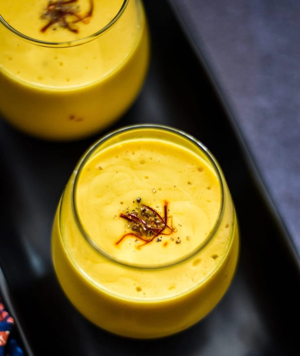 two glasses cold summer cocktails with fruit syrups ice cubes